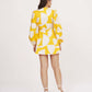 Back view of yellow abstract wrap dress with tie-up detail and full balloon sleeves.