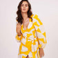 Model smiling in motion in the yellow printed short dress, capturing playful vibe and fabric flow.