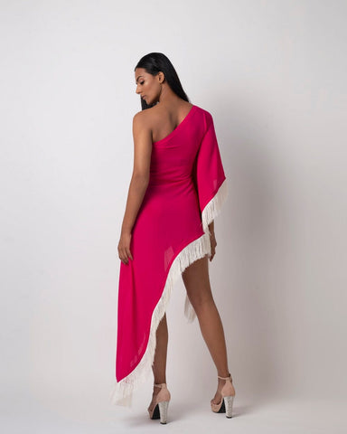 Rear view of the pink one-shoulder kaftan dress showing shell-embellished fringe details and asymmetrical hem