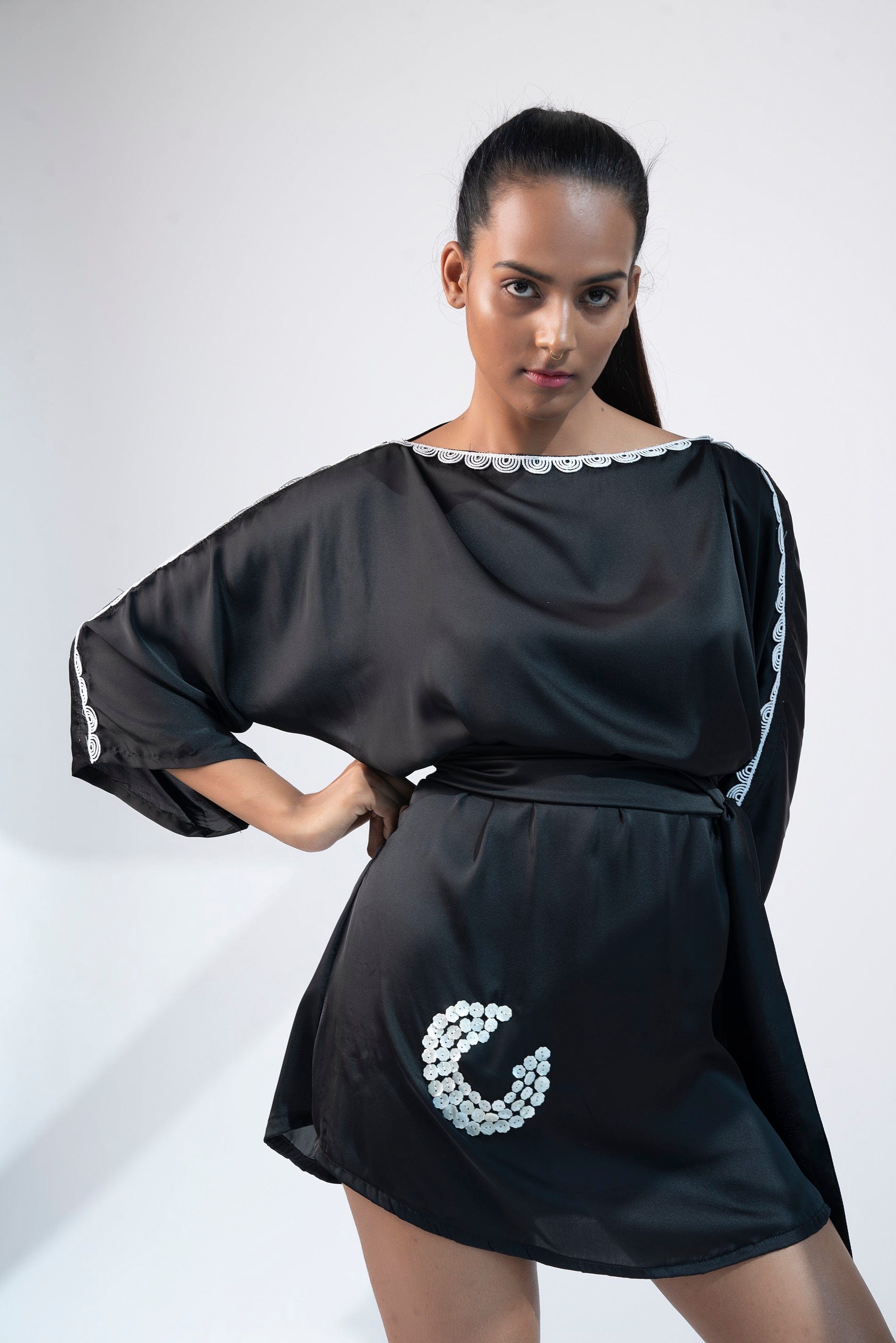 Front view of black kimono mini dress with lace detailing and belted waist.
