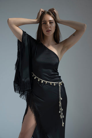 Studio pose with both hands lifted behind head, showcasing neckline and fringe design.