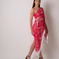 Full front-facing view of model in pink one-shoulder tassel dress with cinched waist and statement hemline.