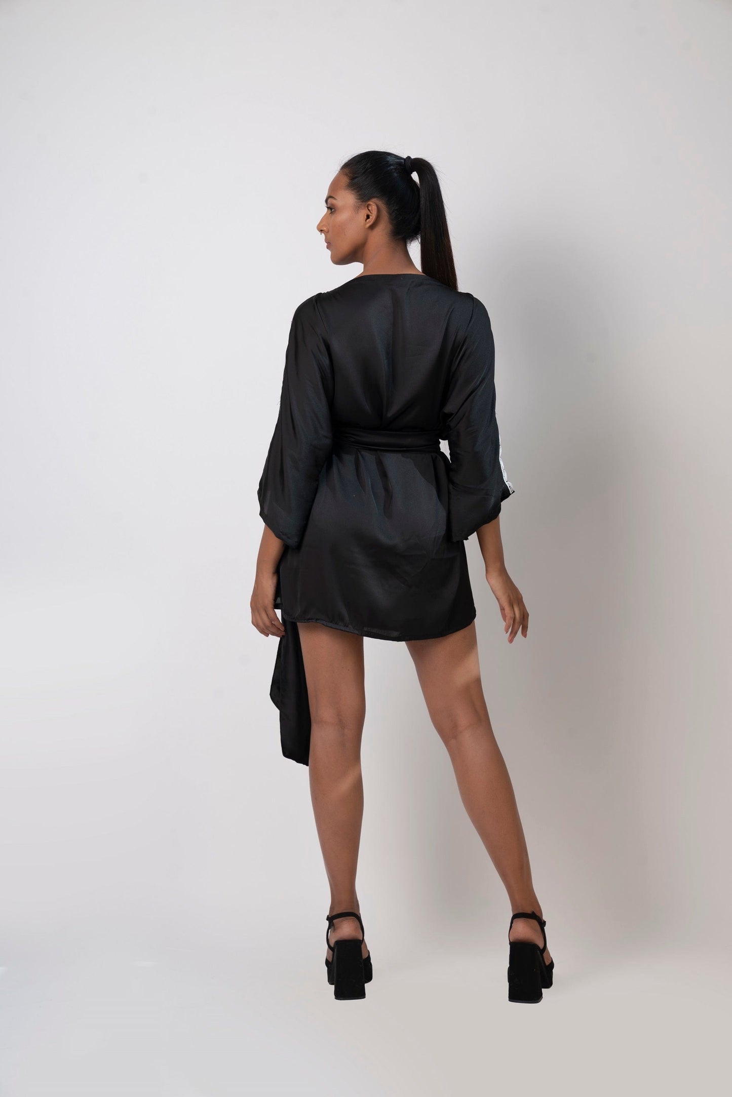 Rear view of black kimono mini dress showcasing back silhouette and flowy kimono sleeves.
