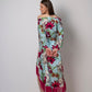 Rear-angle view showing back fit of the off-shoulder blue printed beach dress with relaxed silhouette and fringe hem.