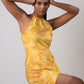 Model pose with hands on head, showcasing the sleeveless halter neck design and wrap-style silhouette.