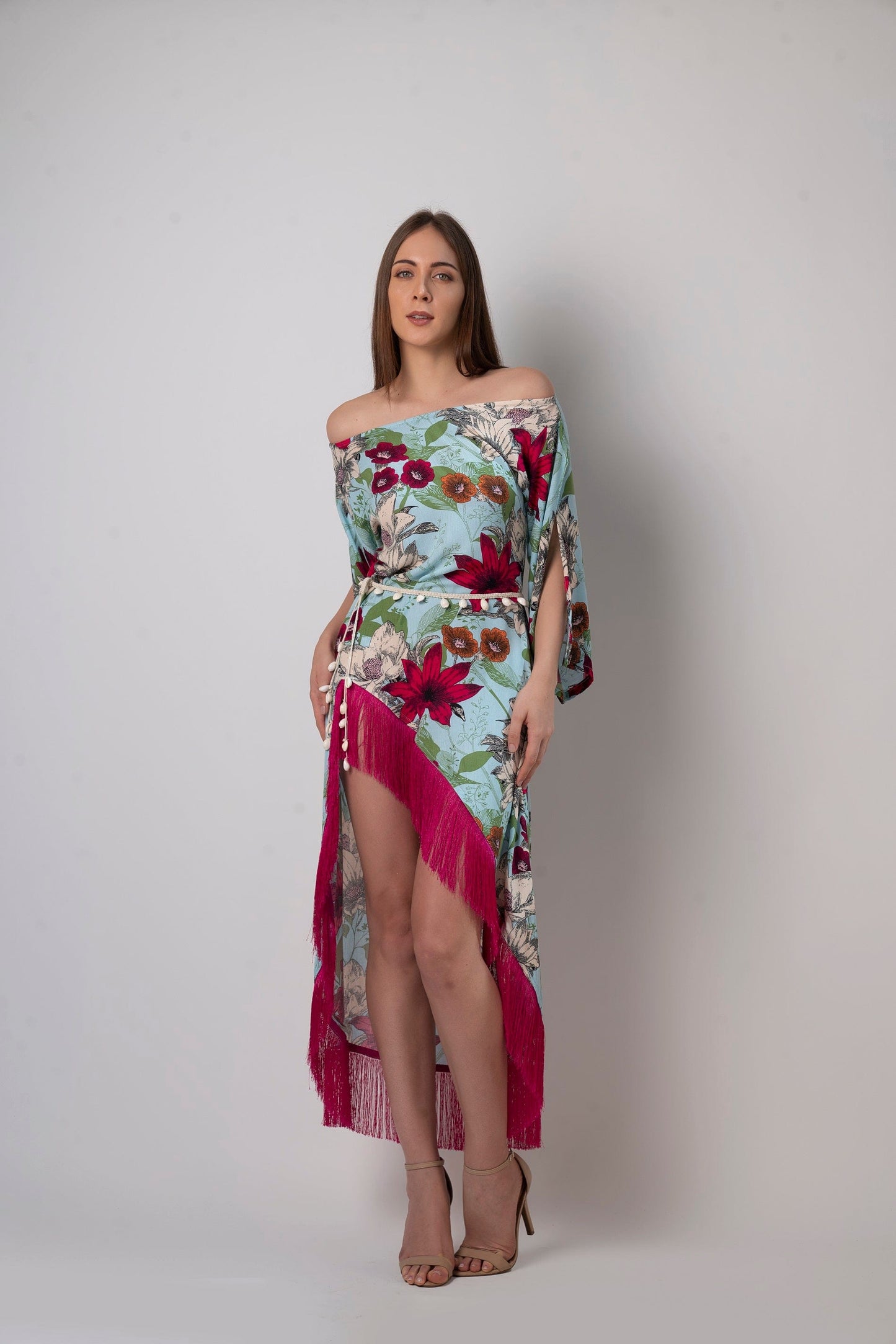 Full-length front pose showing detachable seashell belt and asymmetrical hemline on the flowy blue printed rayon dress.