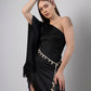 Zoomed-in slightly titled pose of black one-shoulder beach dress with fringes and tied waist belt.