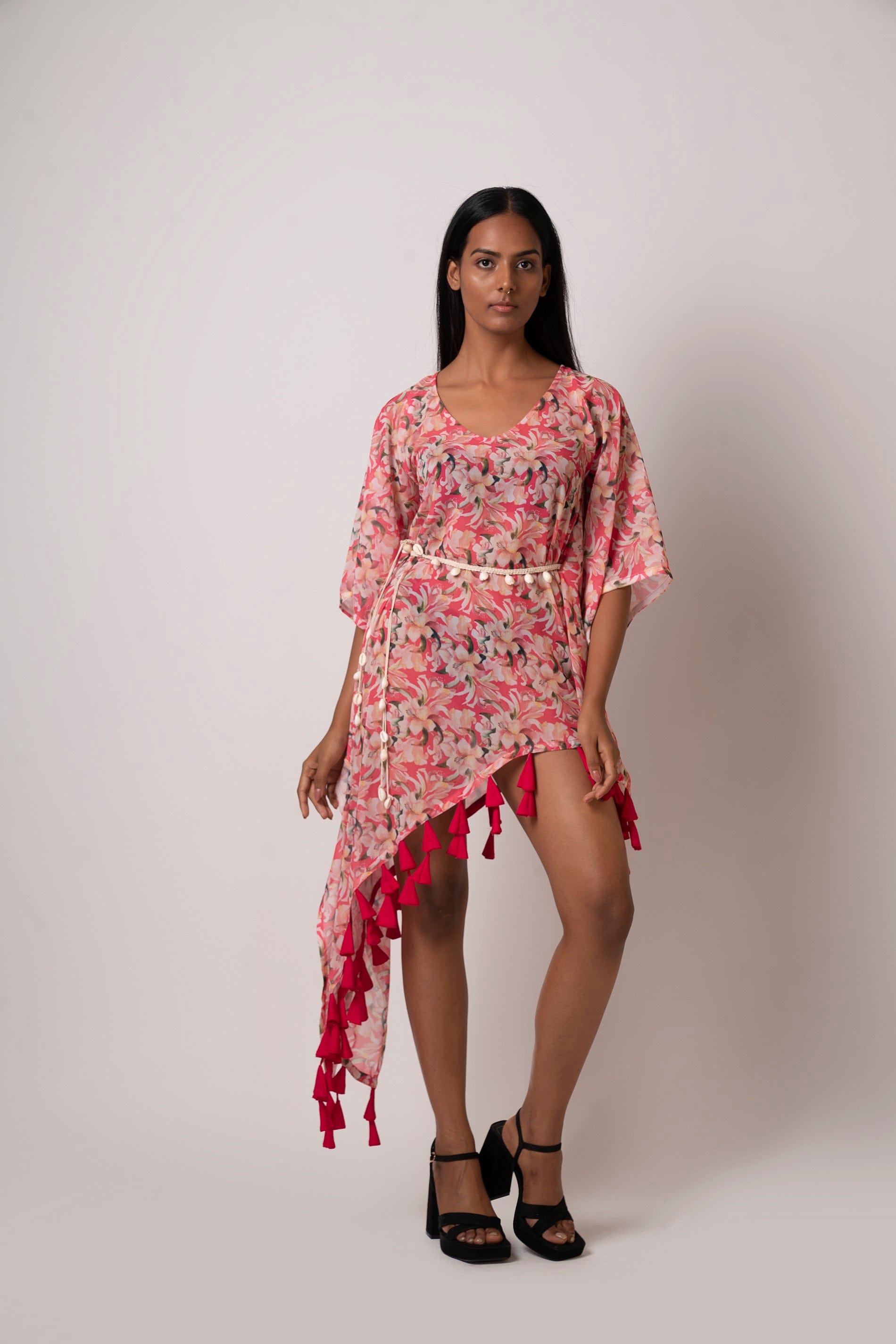 Front view of model standing in pink printed georgette dress with asymmetrical hemline