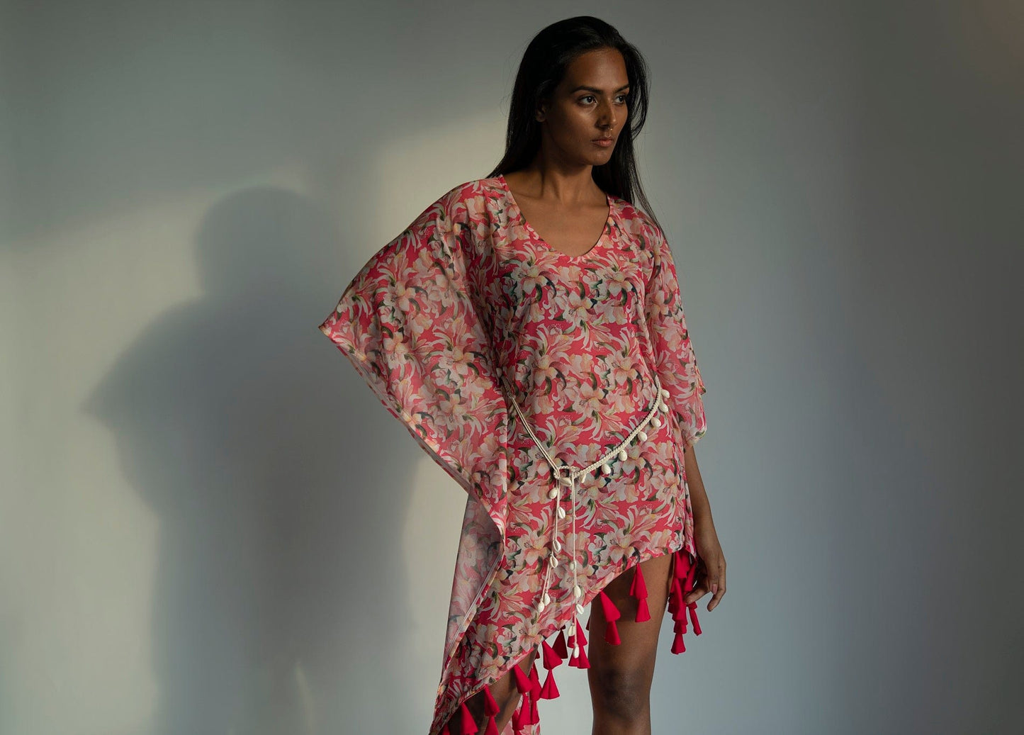 Side view of model in pink floral georgette dress with hands on waist