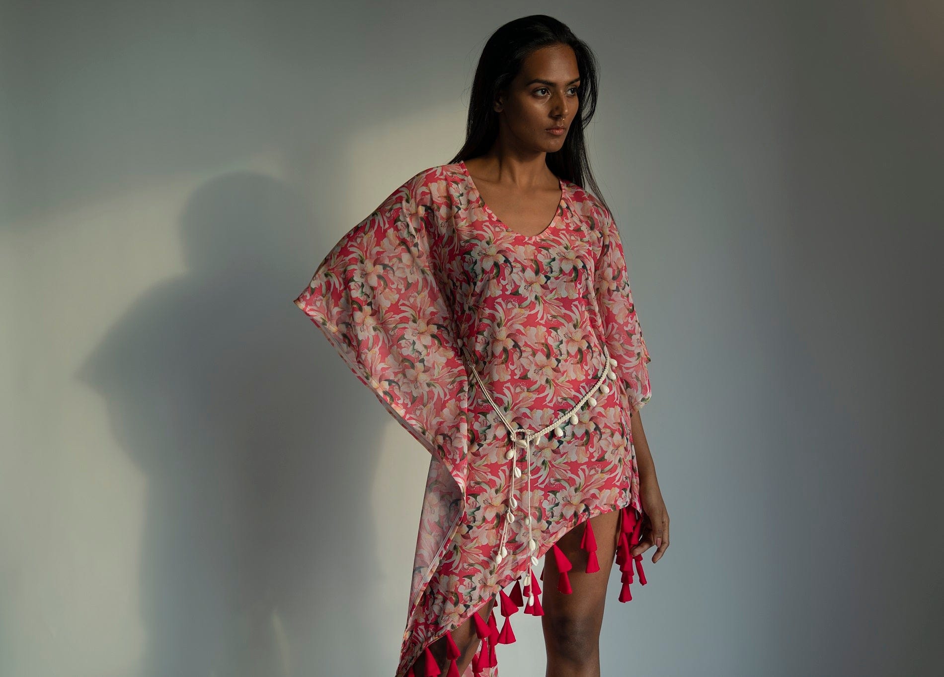 Side view of model in pink floral georgette dress with hands on waist