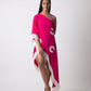 Model poses with one leg raised and slightly bent, showcasing the asymmetrical hem and fringe details of the pink one-shoulder georgette kaftan dress