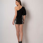 Back view of black mini dress with puff sleeve and side panel detailing.