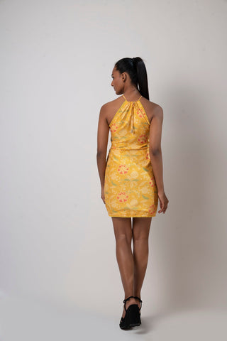Rear view of the tulip-cut yellow dress showing open back halter neck design and flowy silhouette.